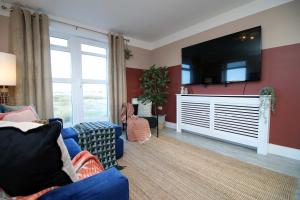 a living room with a large flat screen tv on a wall at Stylish modern retreat overlooking Poole Quay in Poole