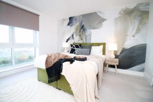 a bedroom with a bed with a painting on the wall at Stylish modern retreat overlooking Poole Quay in Poole