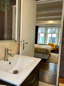 a bathroom with a sink and a bedroom with a bed at Amsterdam 4 Holiday GuestRooms in Amsterdam