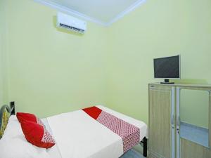 a room with a bed with a tv on a wall at OYO 91974 Alfisal Syariah in Bagam