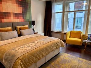 a bedroom with a bed and a chair and windows at Amsterdam 4 Holiday GuestRooms in Amsterdam