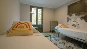 a room with two beds and a window at Smartr Barcelona Ramblas in Barcelona