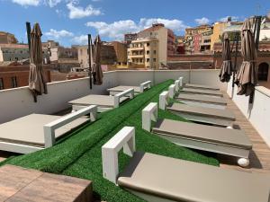 a row of beds on the roof of a building at Neko Boutique Hotel in Cagliari