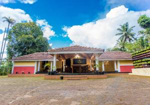 a house with a red and white at Chandragiri Wayanad Traditional Bungalow by VOYE HOMES in Vaduvanchal