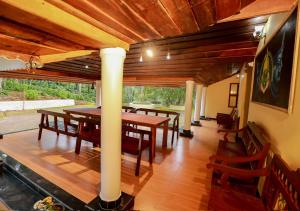 a dining room with a table and wooden floors at Chandragiri Wayanad Traditional Bungalow by VOYE HOMES in Vaduvanchal