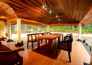 a wooden table and chairs under a wooden ceiling at Chandragiri Wayanad Traditional Bungalow by VOYE HOMES in Vaduvanchal