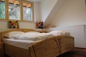 a bed sitting in a room with two windows at Waldhof in Villach