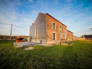 un edificio de ladrillo en un campo con césped en Beautiful holiday home with a unique location in the middle of nature en Gesves