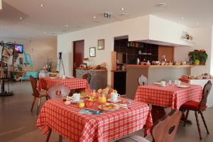 テュルクアイムにあるレ ポルト デ ラ ヴァレのキッチン(テーブル2台、赤と白のテーブルクロス付)