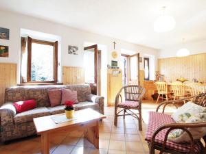 een woonkamer met een bank en een tafel bij Wooden chalet in Pieve Tesino with garden in Pieve Tesino