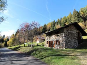 een stenen gebouw aan de kant van een weg bij Wooden chalet in Pieve Tesino with garden in Pieve Tesino