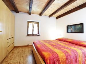 een slaapkamer met een groot bed en een raam bij Wooden chalet in Pieve Tesino with garden in Pieve Tesino