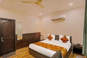 a bedroom with a large bed and a mirror at Hotel Grand Tushar - Near Ghaziabad Railway Station in Ghaziabad