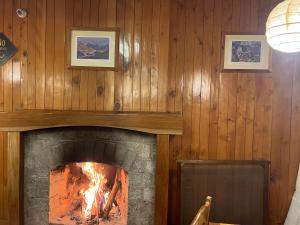 a fireplace in a wooden wall with a fire in it at Hotel Negi's Mayflower A heritage Since 1965 in Manāli