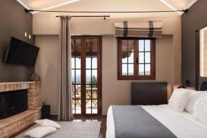 una camera con letto e camino di GM Luxury Suites Kalavryta a Kalavrita