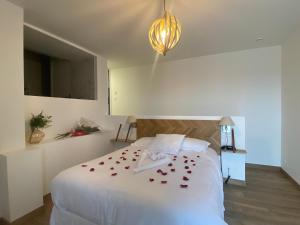 a bedroom with a white bed with red roses on it at LA TOUR AUX CRABES près de la plage in Dieppe