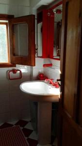 a bathroom with a white sink and red cabinets at Casa Rosalba in San Vito lo Capo