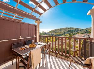 een patio met een tafel en stoelen op een balkon bij Village Pierre & Vacances Cap Esterel - Saint Raphaël Village in Agay - Saint Raphael