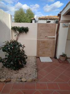 a garage with a wooden door next to a building at Casa Patrizia in Olbia