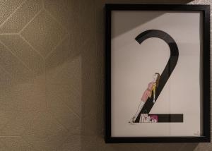 a painting of a black and white cat on a wall at Hôtel La Parizienne by Elegancia in Paris