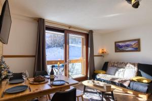 ein Wohnzimmer mit Tisch und Couch in der Unterkunft Aux Rêveries des Cimes - Vostok Zodiaque in Villarembert