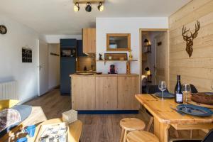 ein Wohnzimmer mit Tisch und Küche in der Unterkunft Aux Rêveries des Cimes - Vostok Zodiaque in Villarembert + 10 Fotos