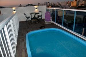 a swimming pool on the roof of a building at Vila Suítes Coliving in Vila Velha