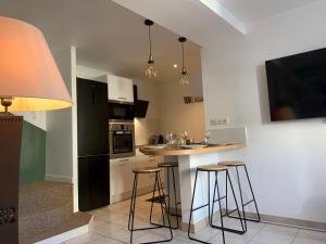 a kitchen with a counter and bar stools at Kris Sweet Home in Romagnat