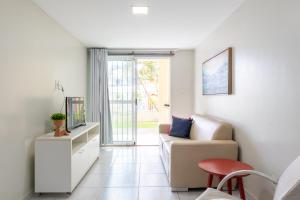 a living room with a couch and a tv at Ocean Residence in Porto De Galinhas