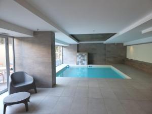 a large swimming pool with a chair and a table at Gran Hotel Dakar in Mendoza