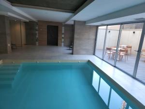 a large swimming pool with a table and a dining room at Gran Hotel Dakar in Mendoza