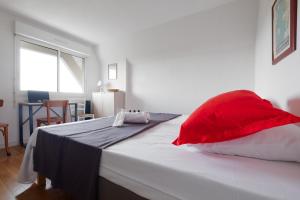 ein Schlafzimmer mit einem großen Bett mit roten Kissen in der Unterkunft Résidence Belle Vue YourHostHelper in Arcachon