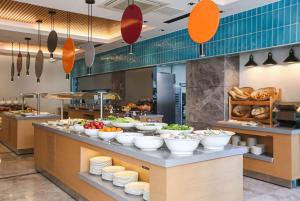 a buffet line with bowls of vegetables and bread at Ramada Plaza Sultanahmet in Istanbul