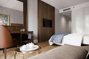 Ramada Plaza Sultanahmet في إسطنبول: غرفة نوم بسرير وطاولة واريكة