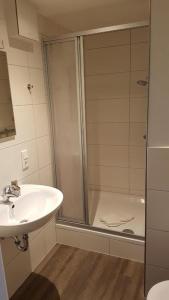 La salle de bains est pourvue d'une douche et d'un lavabo. dans l'établissement Hafenloft App 1, à Norderney