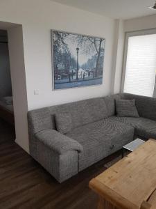 - un salon avec un canapé et une table dans l'établissement Hafenloft App 1, à Norderney