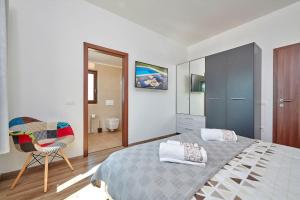 Un dormitorio con una cama, una silla y un espejo. en VILLA GIOVANNA POREC, en Poreč 58 fotos más