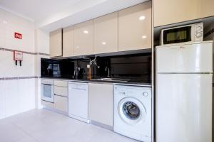 una cocina blanca con lavadora y secadora. en IM On House of Organa, en Lagos 11 fotos más