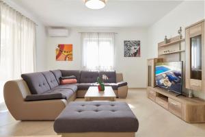 Una sala de estar con un sofá y un televisor. en VILLA GIOVANNA POREC, en Poreč
