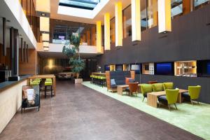 a lobby with tables and chairs in a building at Tailormade Hotel SIHLPARK Schindellegi in Schindellegi