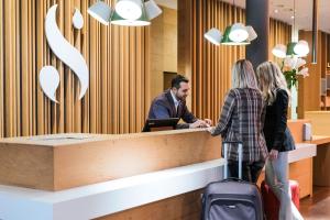 a group of people standing at a reception desk at Tailormade Hotel SIHLPARK Schindellegi in Schindellegi