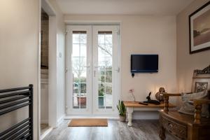 a living room with a window and a tv on the wall at Clai Cerrig in Llangefni