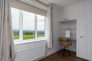 a window with a desk and a chair in a room at Clai Cerrig in Llangefni