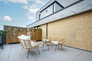 a patio with chairs and a table and a brick wall at Be London - The London Residences in London