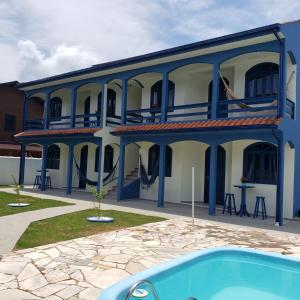 un edificio azul y blanco con piscina en Casa Miosótis apartamentos, en Palhoça