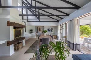 a living room with a ceiling with beams at Bitou River Lodge in Plettenberg Bay