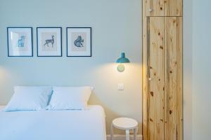 een slaapkamer met een wit bed en een houten kast bij Majestic Alpin - A luxurious apartment with a nordic feel in Chamonix-Mont-Blanc
