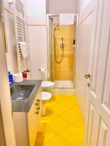 ein Bad mit einem Waschbecken, einem WC und einer Dusche in der Unterkunft All Suite Colosseo in Rom