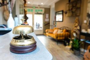 a bell sitting on a counter in a living room at Hôtel Le Patio - Deauville in Deauville