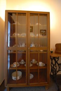 une armoire en bois avec des assiettes et de la vaisselle dans l'établissement Gästehaus Balzer, à Marbourg